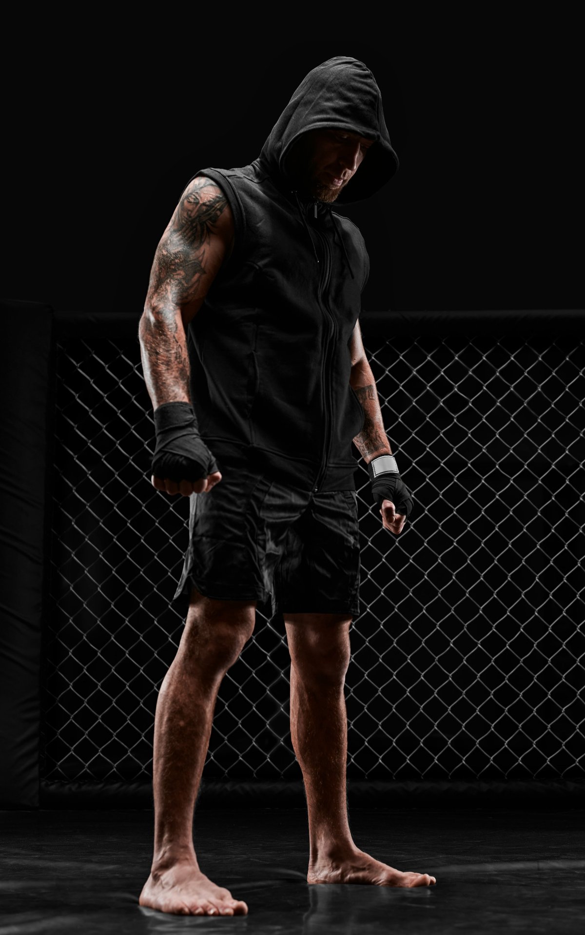 Conceptual image of a kickboxer. A real fighter stands in the real cage of the octagon. The concept of mixed martial arts, kickboxing, sports schools. Mixed media